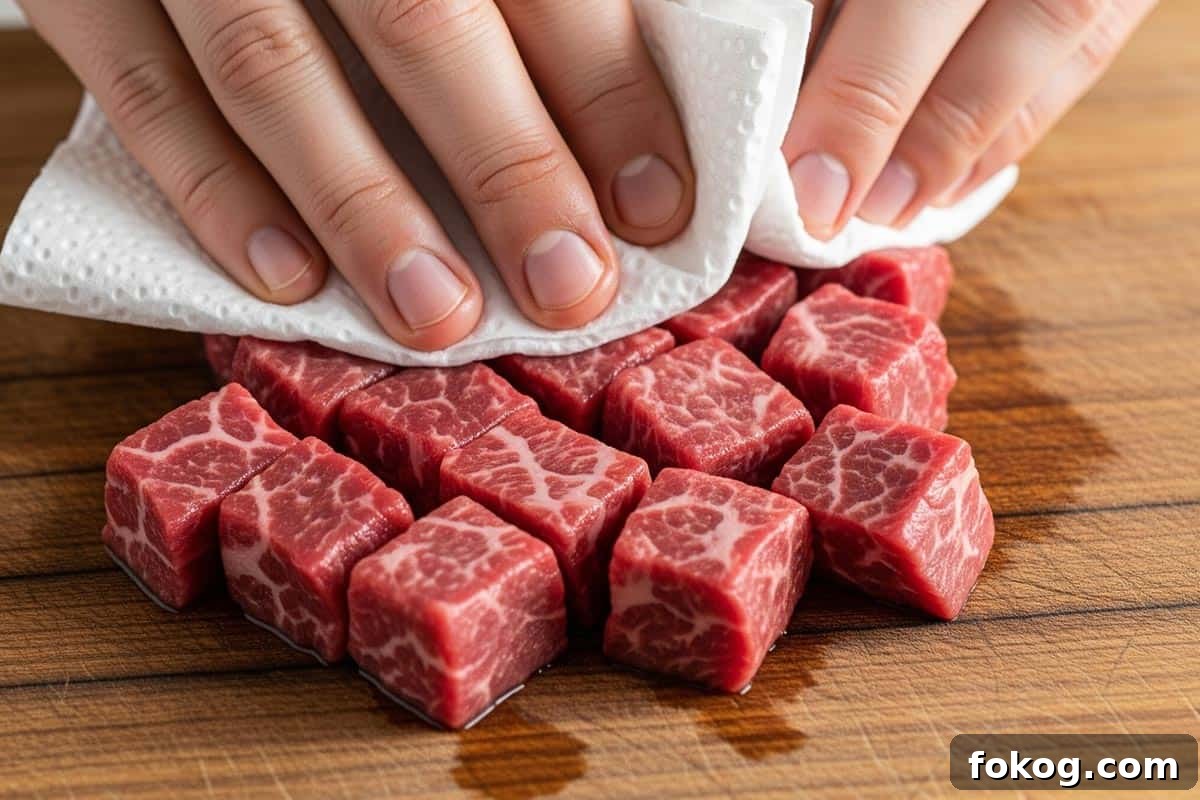 Patting the beef cubes dry using paper towel.