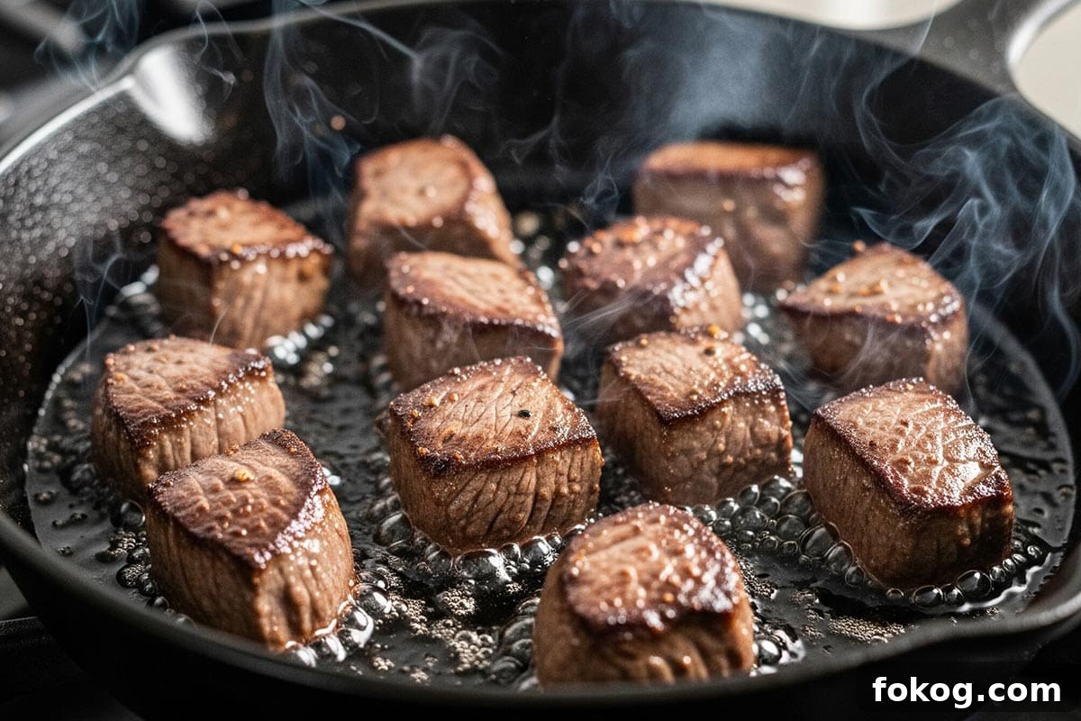 Searing the beef until browned in a skillet.