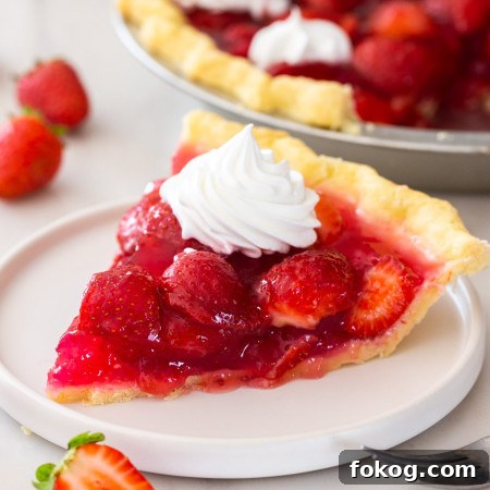Fresh Strawberry Pie Recipe: Classic No-Bake Summer Dessert 8 A slice of fresh strawberry pie on a small white plate, with whipped cream on top