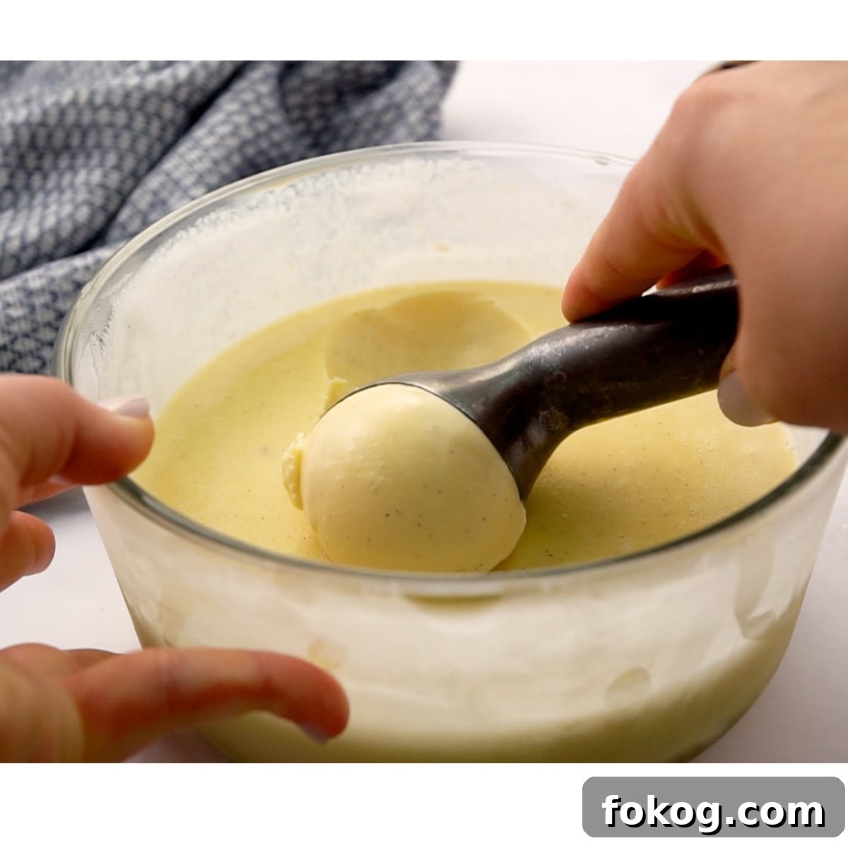 Homemade Vanilla Ice Cream (No Ice Cream Maker Needed) 8 scooping frozen homemade vanilla ice cream out of Pyrex bowl