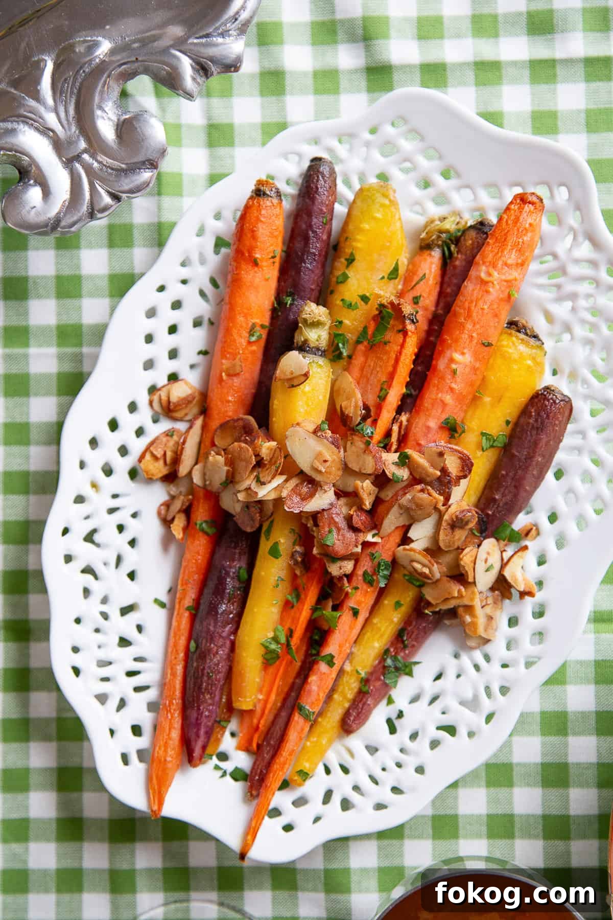 brown sugar glazed carrots on a white platter on a green gingham tablecloth.