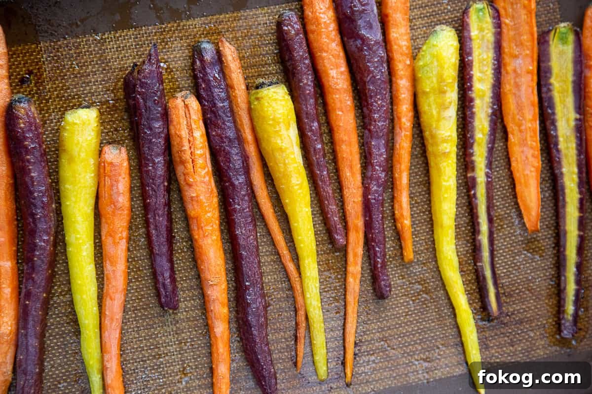 cooked rainbow carrots on a sheet pan.
