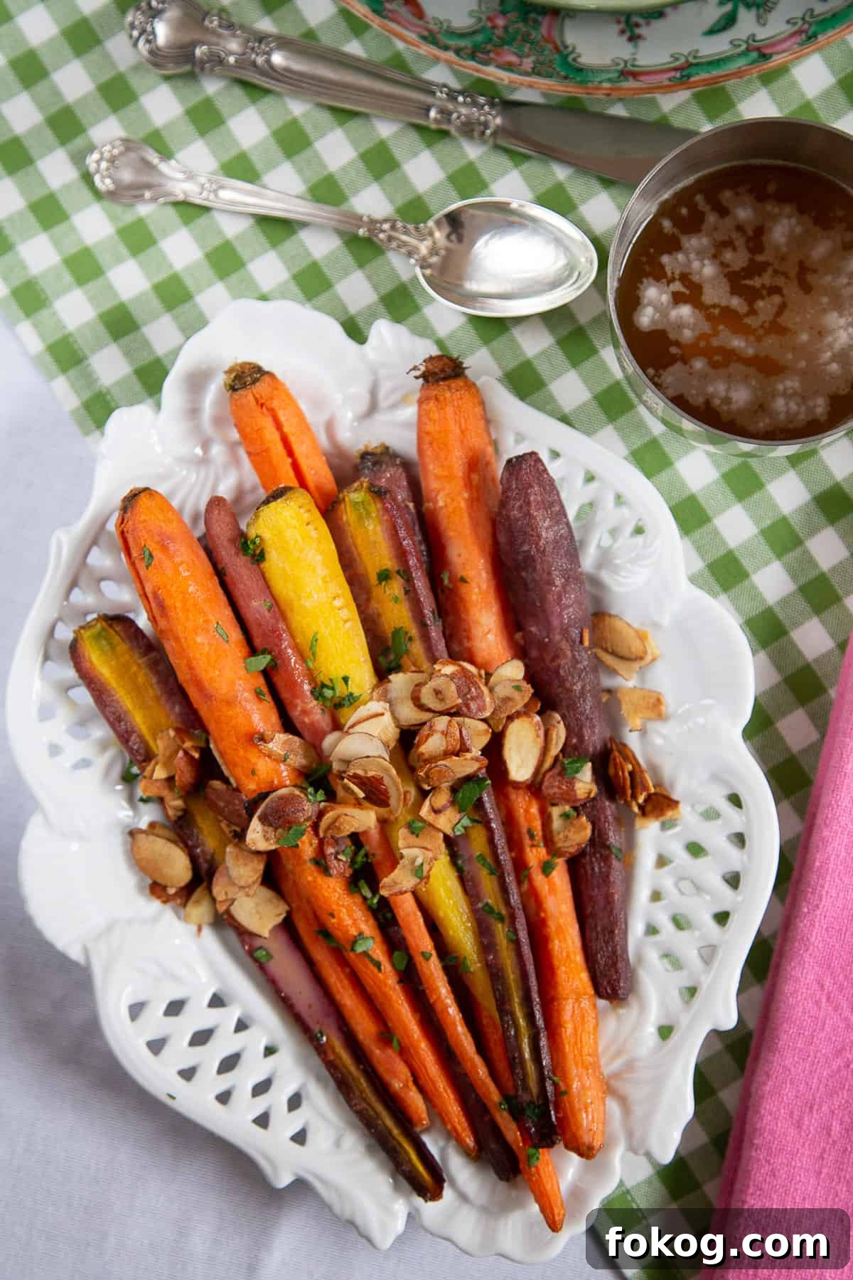 brown sugar glazed carrots topped with sliced almonds on a white platter.