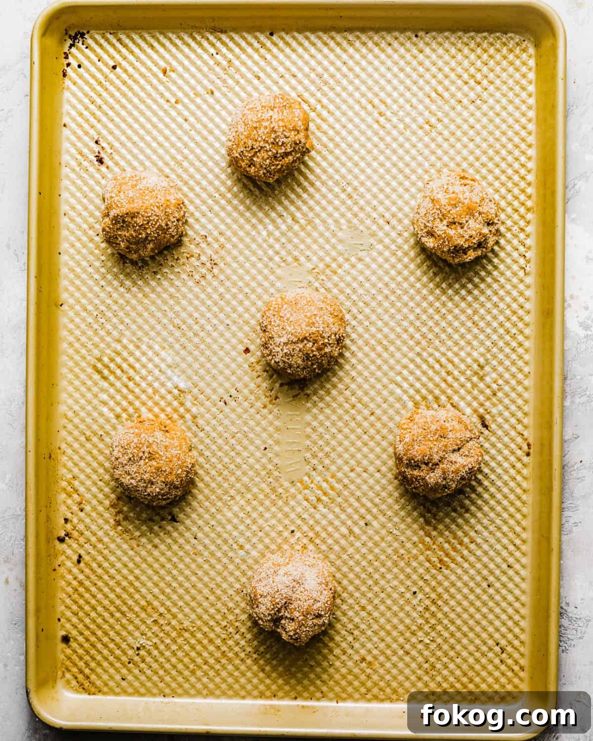 cookie dough balls on a baking sheet.