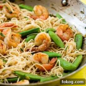 Shrimp, Sugar Snap Pea and Scallion Stir Fry with Miso Sauce in wok on table.