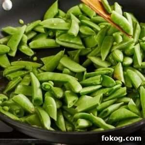Sauteing sugar snap peas in pan.
