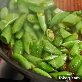 Seasoned Soy Glazed Sugar Snap Peas cooking in pan.