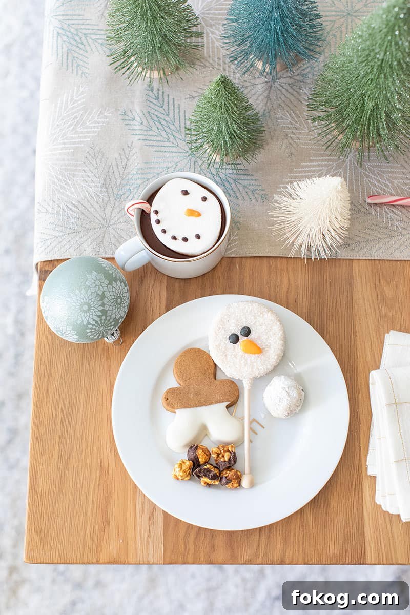 Holiday desserts on a gold and white plate with a snowman cake pop and gingerbread cookie. 