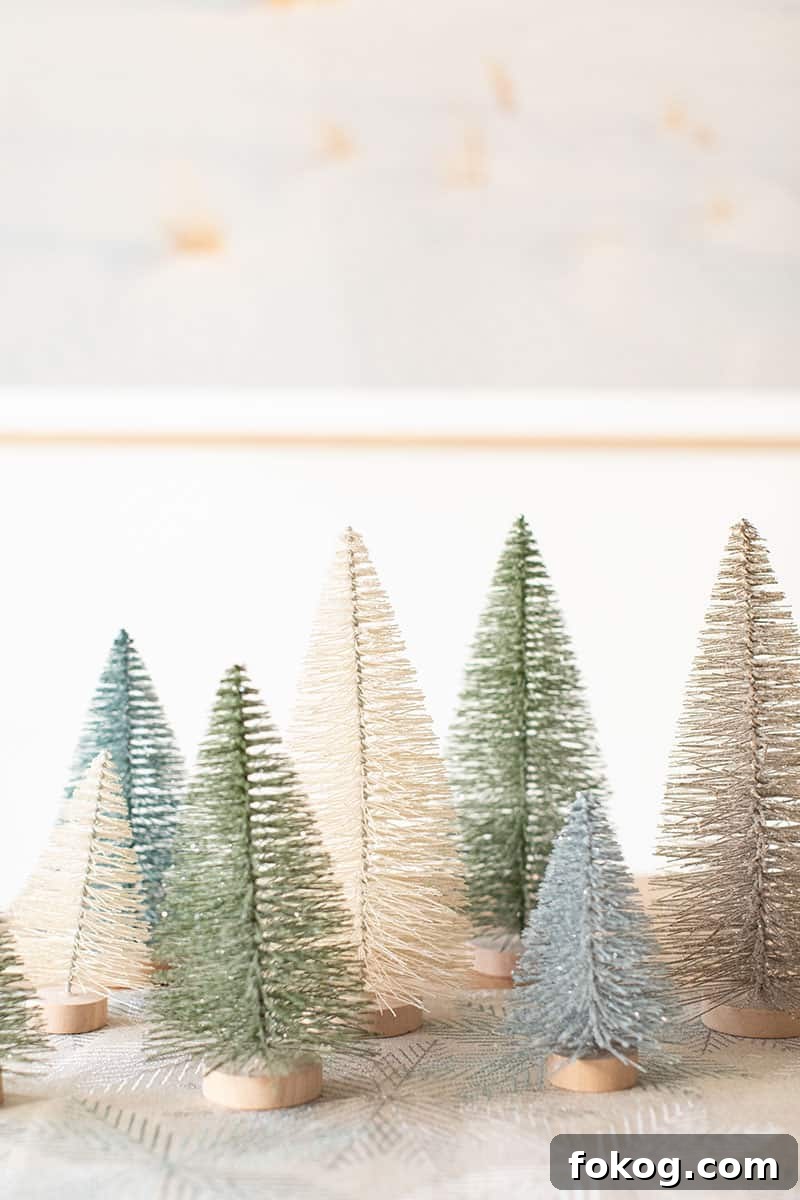 Blue, green and white bottle brush Christmas trees on a table. 