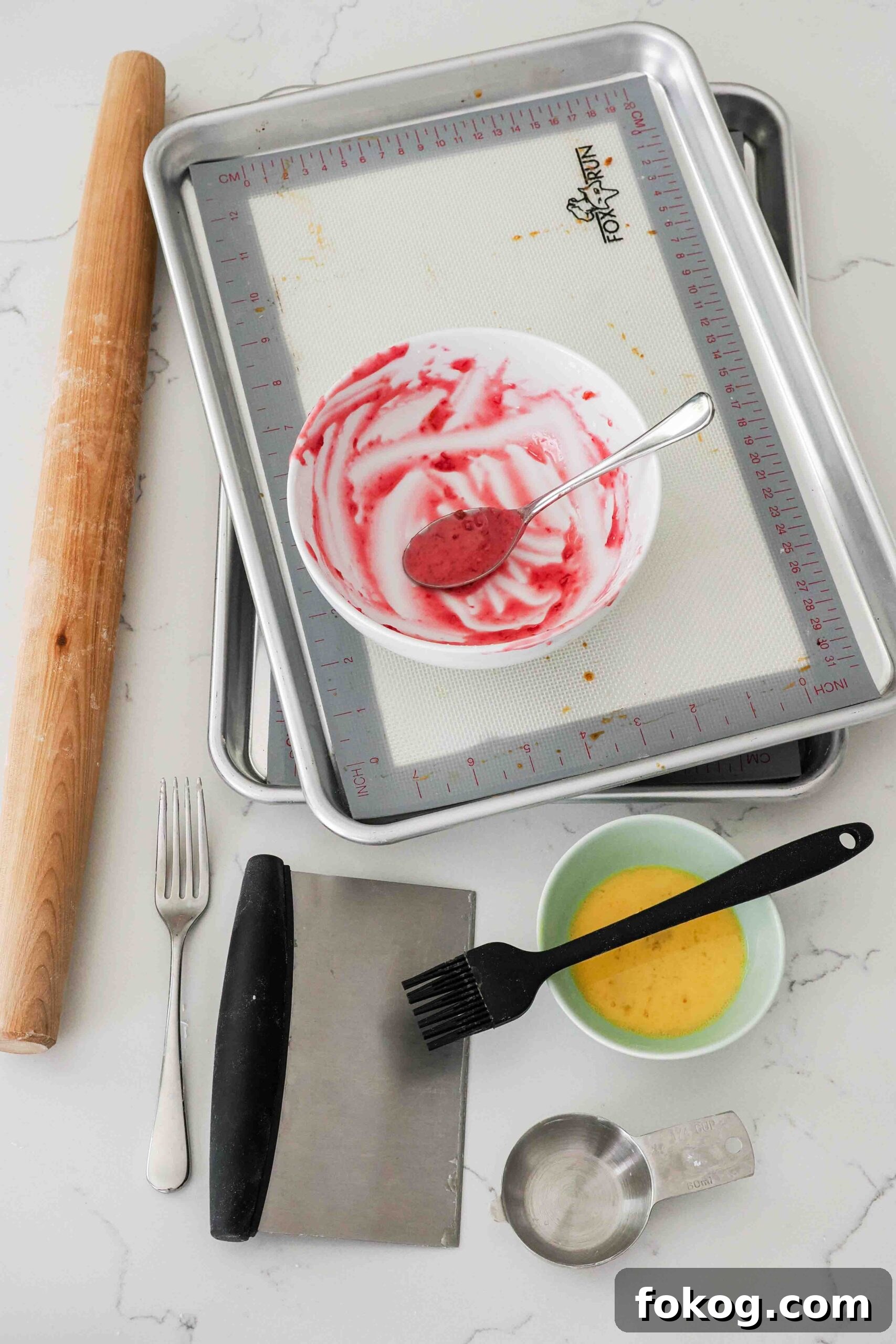 Dishes used to make homemade cherry pop tarts on a kitchen counter.