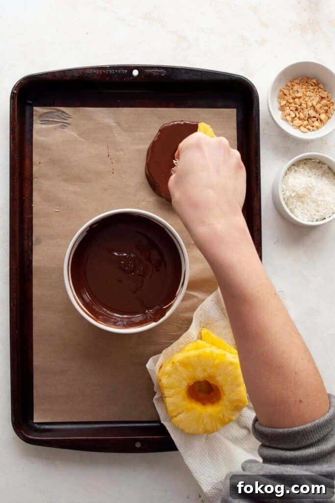 Chocolate-Covered Pineapple Recipe: Sweet Tropical Treat in Minutes 7 decorating chocolate covered pineapple with shredded coconut and chopped peanuts