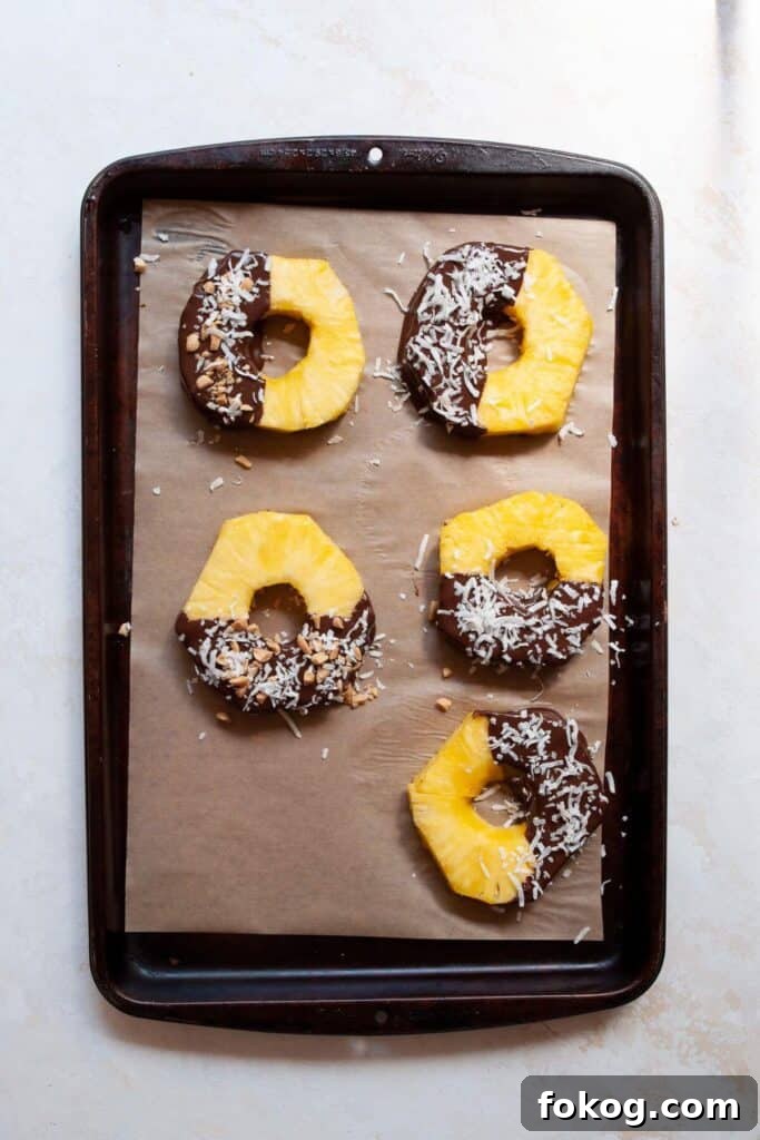 Chocolate-Covered Pineapple Recipe: Sweet Tropical Treat in Minutes 8 pineapple rings on a baking sheet after being dipped in chocolate