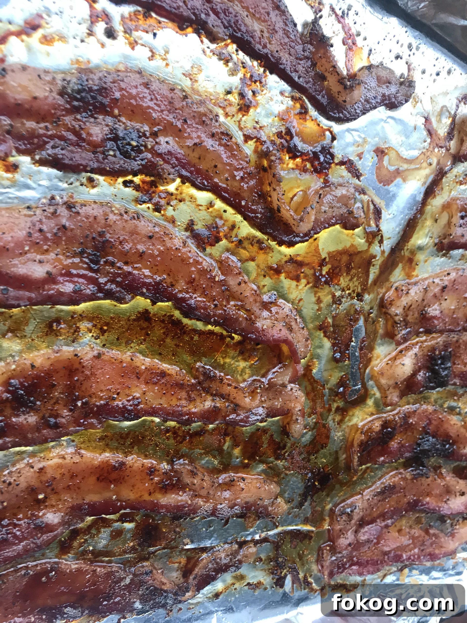 The bacon, after cooking, on the baking sheet.