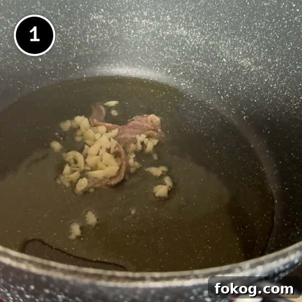 Pasta e Ceci – Italian Pasta with Chickpeas | cookeatworld.com frying garlic and anchovies in a pot