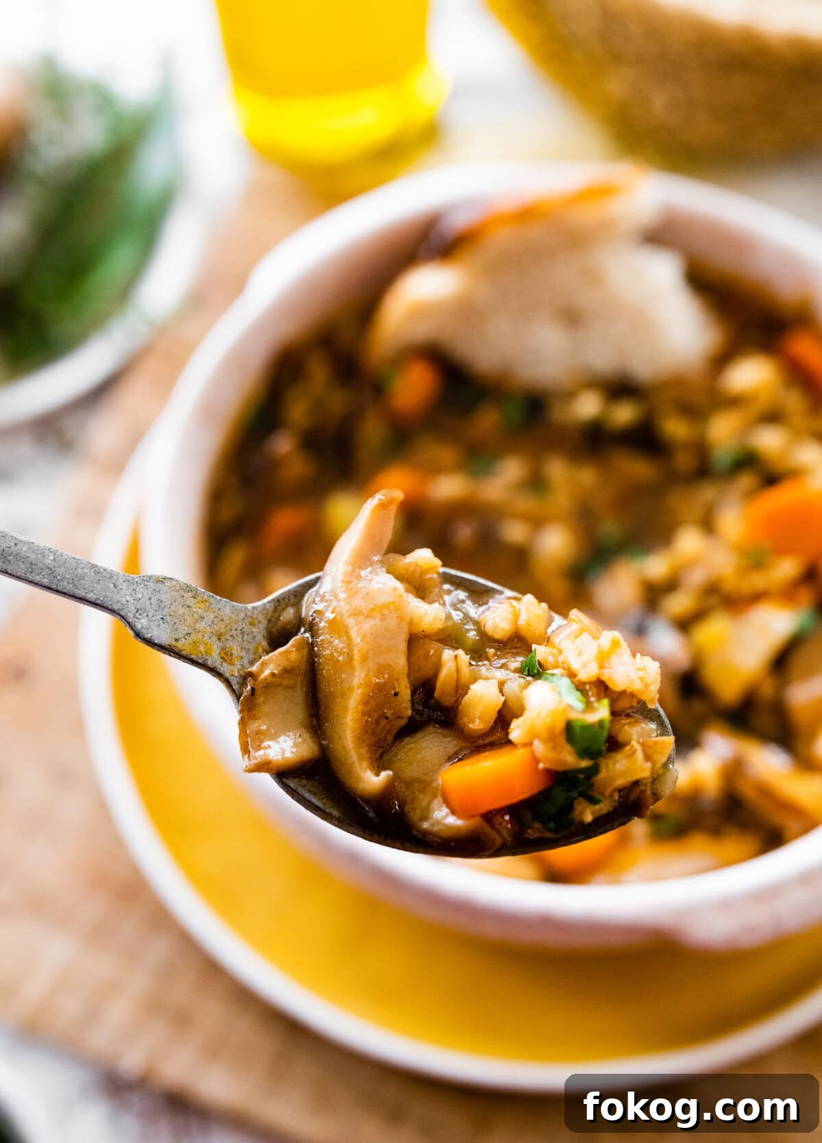 Spoon with a scoop of mushroom barley soup.