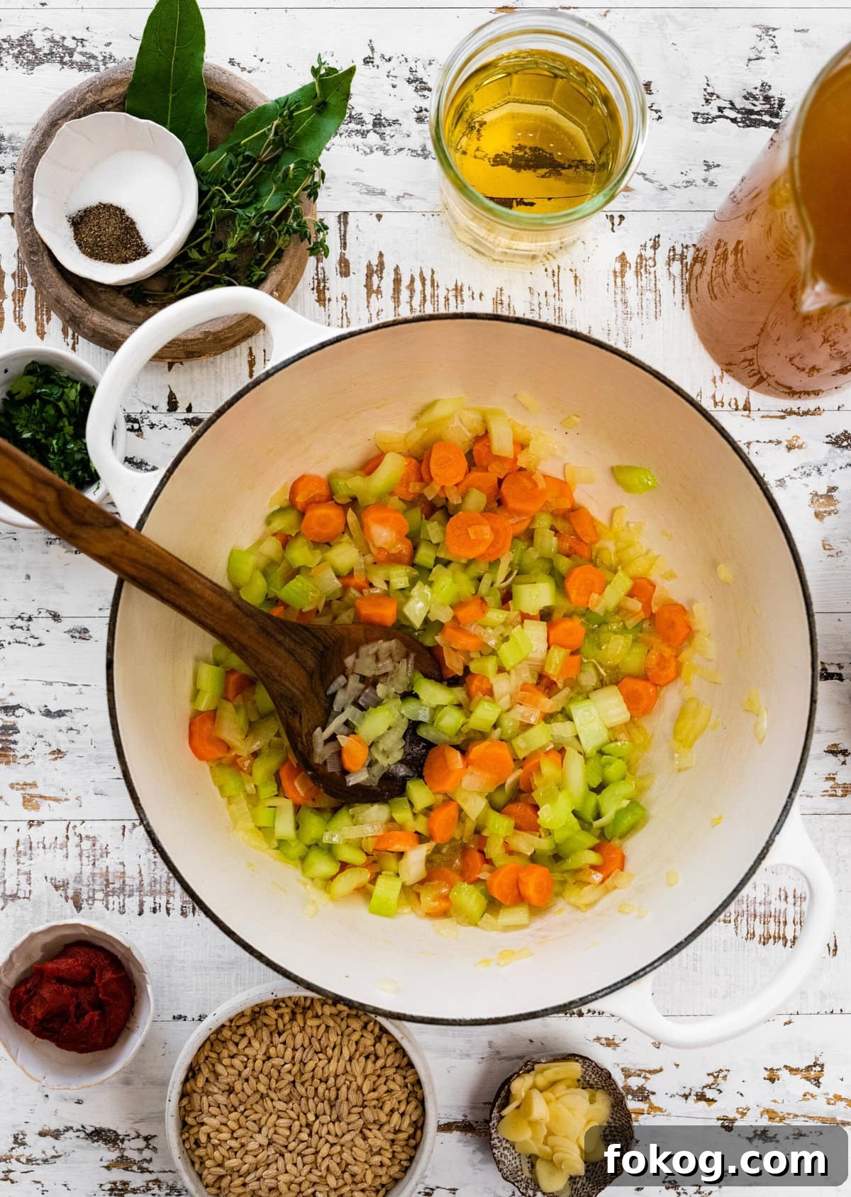 Ladle sauteing chopped vegetables in a Dutch oven.