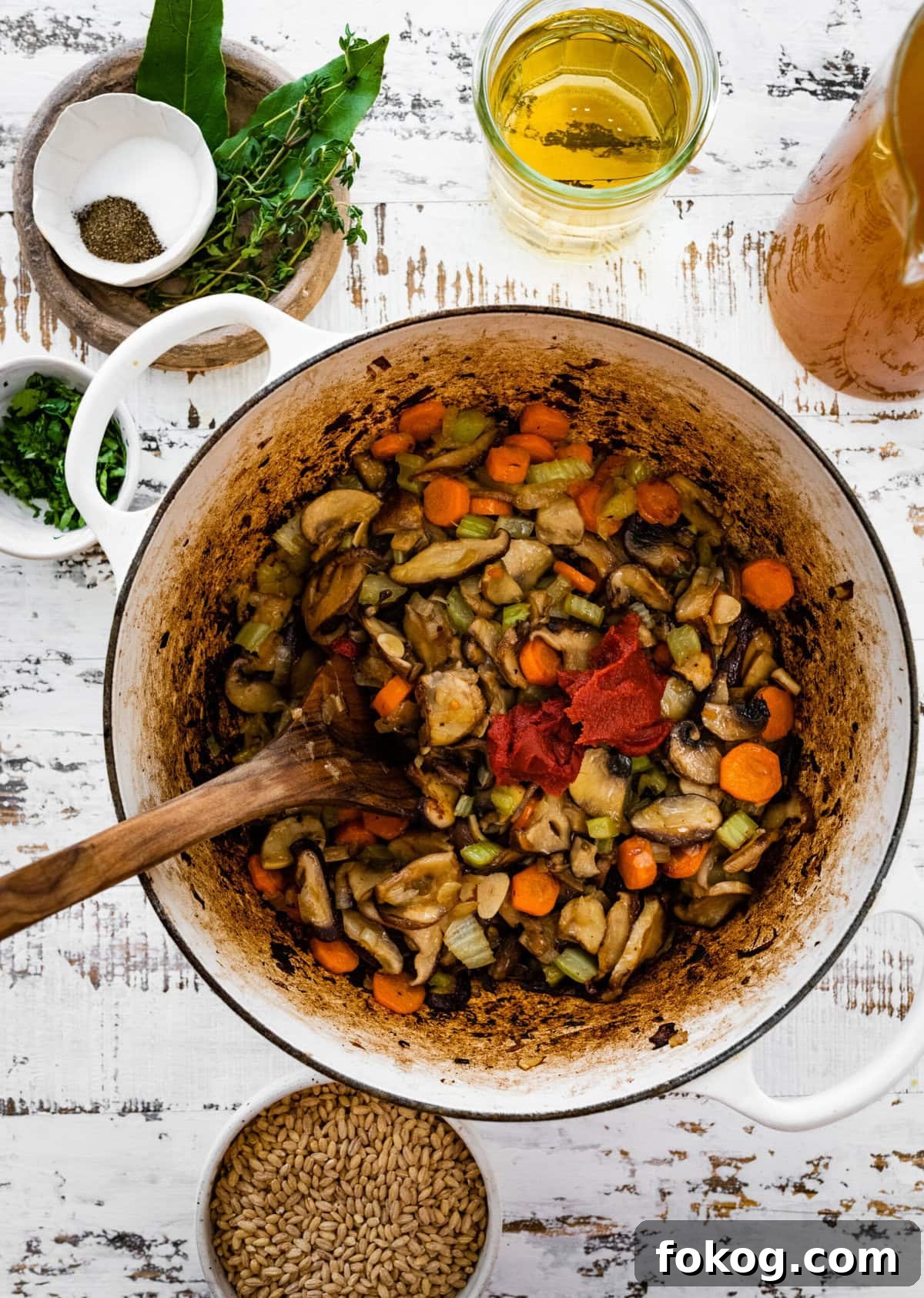 Tomato paste in a Dutch oven with cooked vegetables.