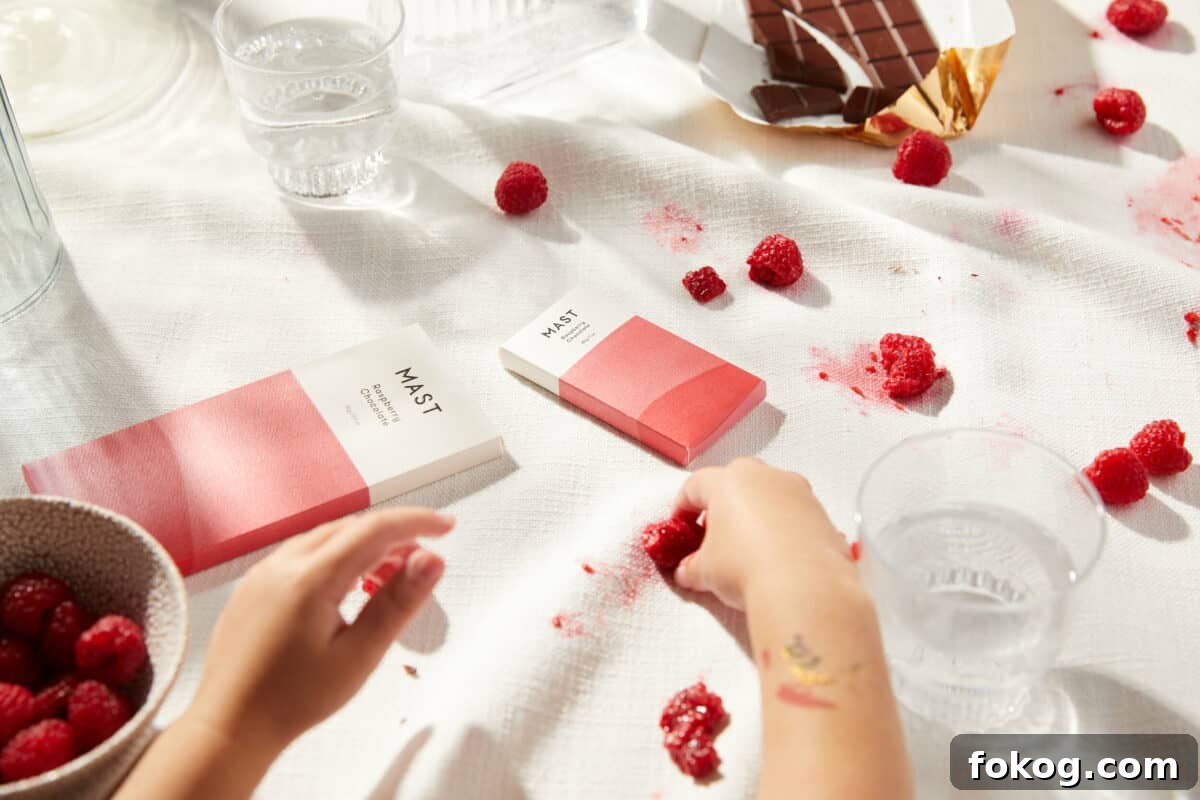 6 Organic Chocolate Brands Low in Heavy Metals 8 chocolates from Mast with berries and a glass of water beside the person's hand