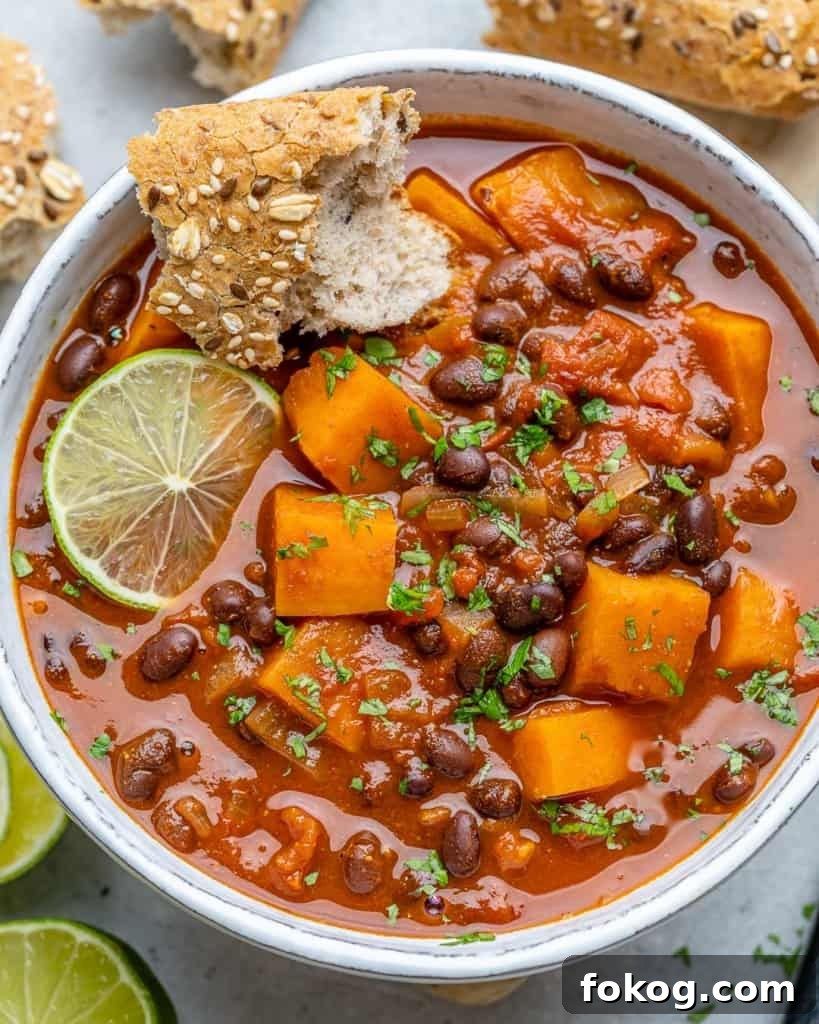 Top-down shot of sweet potato chili in a white bowl with lime granish