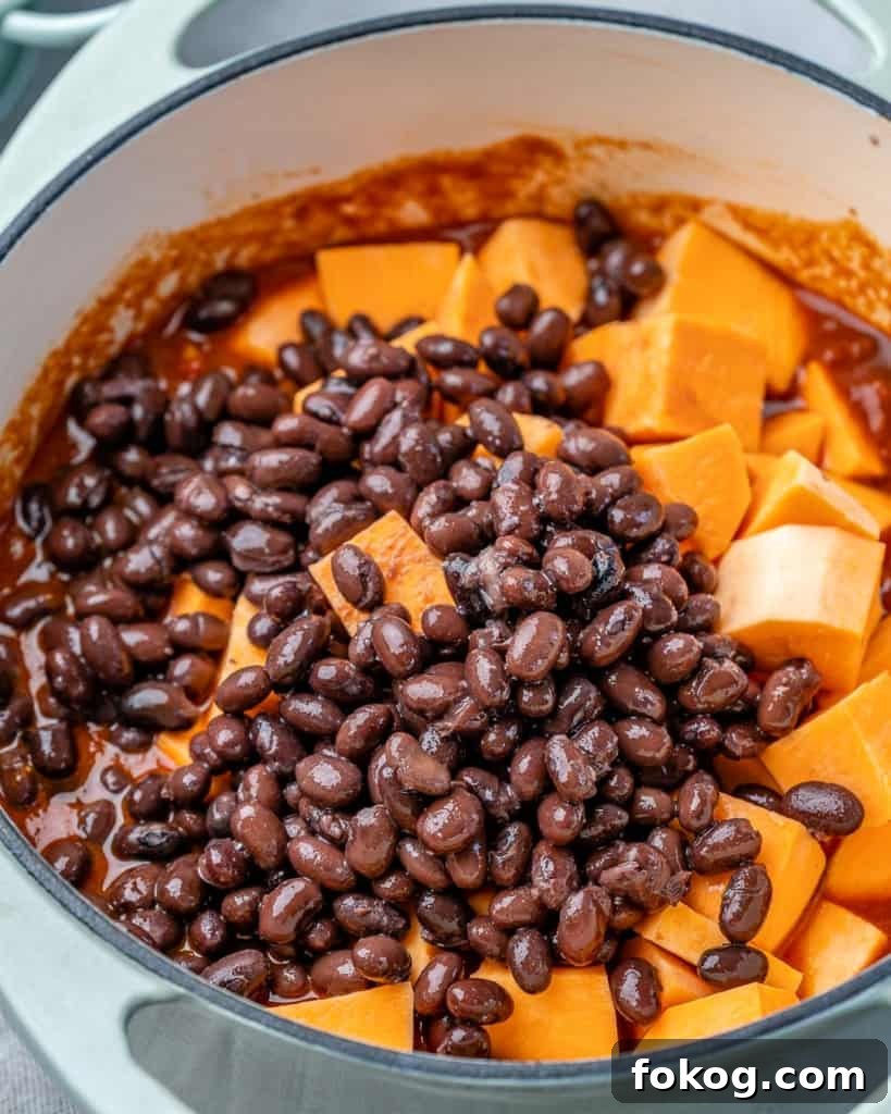 Beans and sweet potatoes in a pot to be cooked into chili