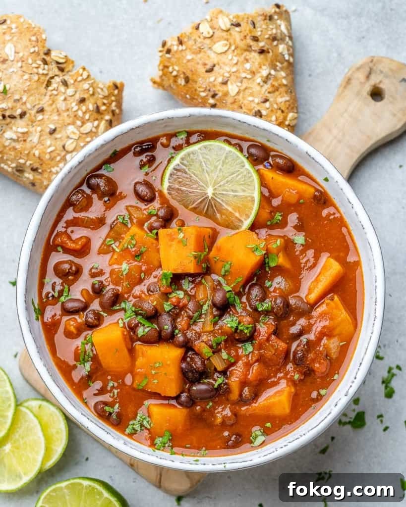 Top down view of sweet potatoa chili in a bowl with bread on the side.