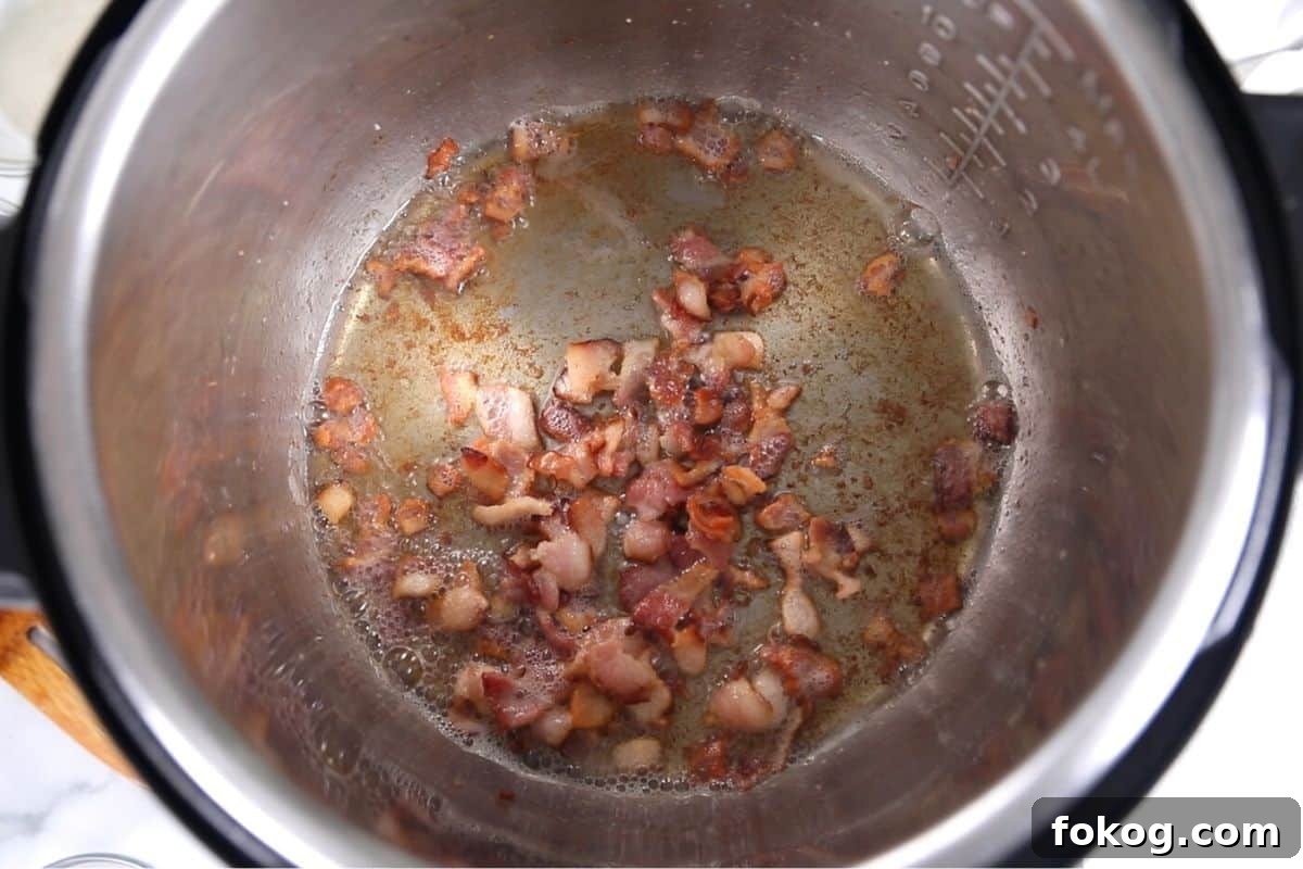 Instant Pot Greens with Bacon Browned Bacon in inner pot of Instant Pot.