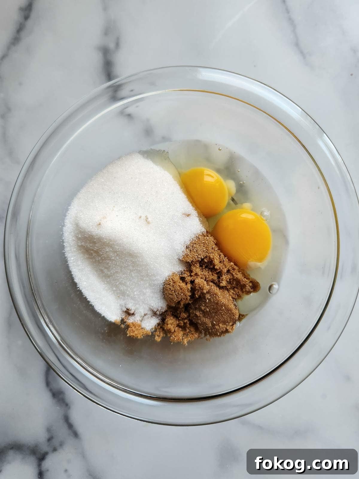 Moist Banana Pecan Muffins Recipe for Breakfast or Brunch 5 Eggs and sugar in a clear bowl.