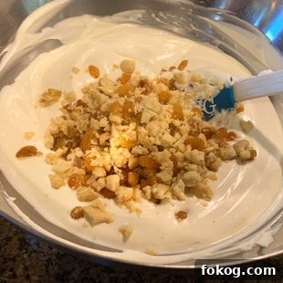 cashews and raisins being added to an ice cream base
