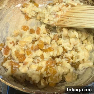 cashews, raisins with cream and milk powder mixture in a pan
