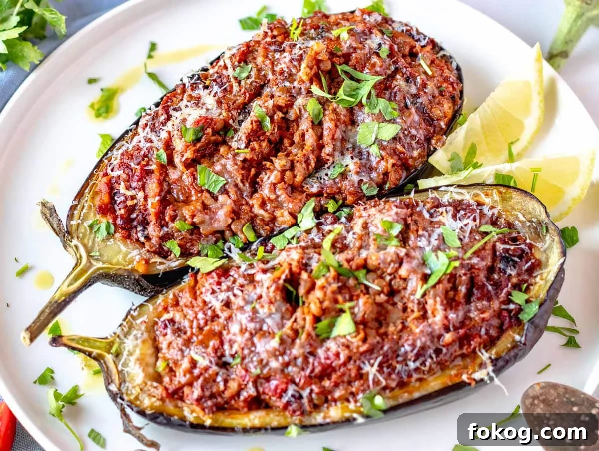 Stuffed eggplant with parmesan and fresh parsley on a white plate