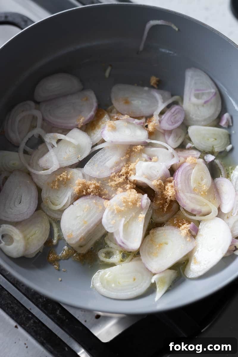 Sliced shallots in a skillet with olive oil, butter and brown sugar. 