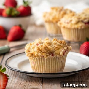 Gluten-Free Strawberry Muffins Recipe with Moist, Tender Crumbs 14 Gluten free strawberry muffin on a white plate sitting on a wooden table.
