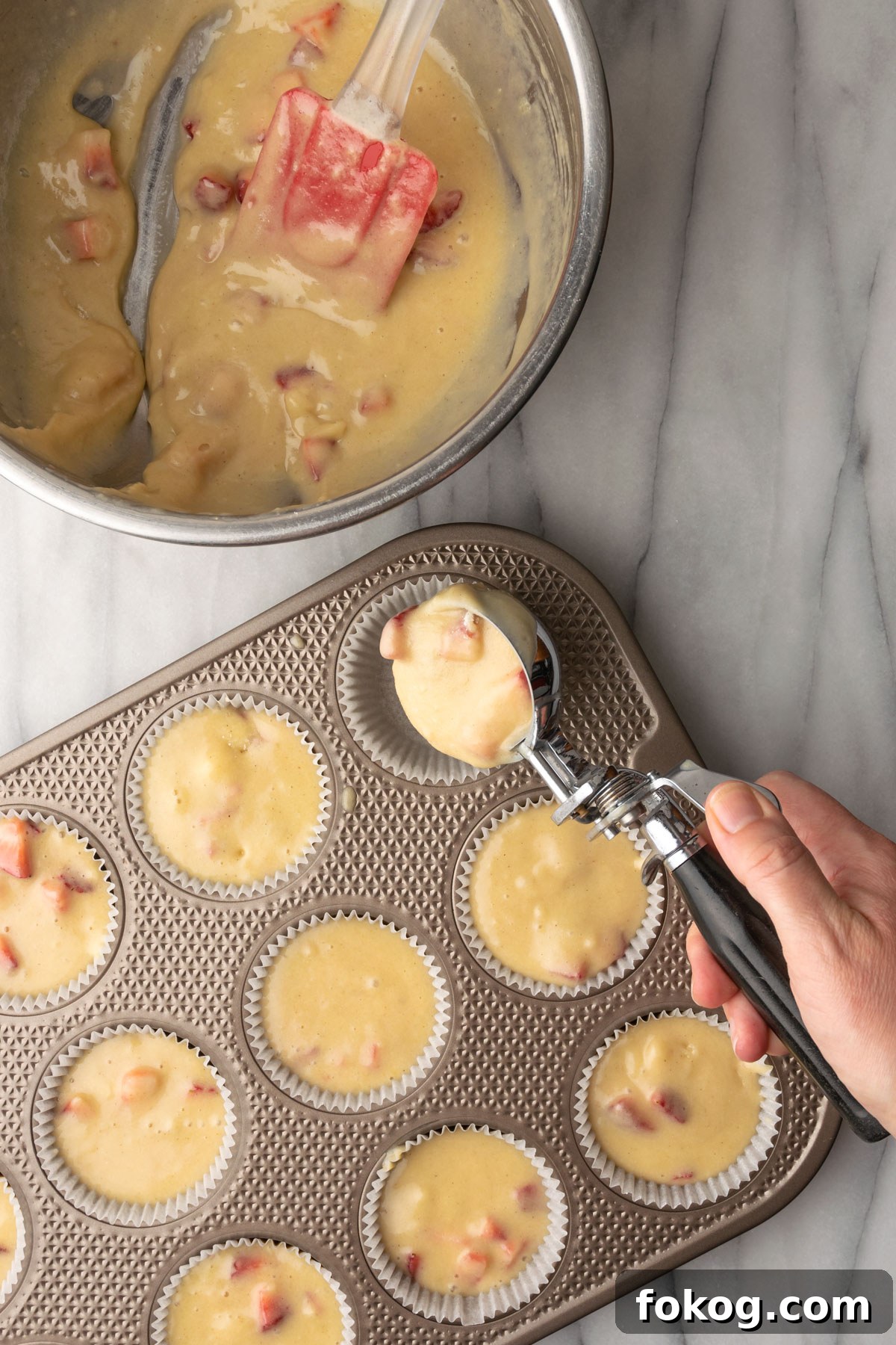 Gluten-Free Strawberry Muffins Recipe with Moist, Tender Crumbs 10 Strawberry muffin batter being portioned into a muffin tin.
