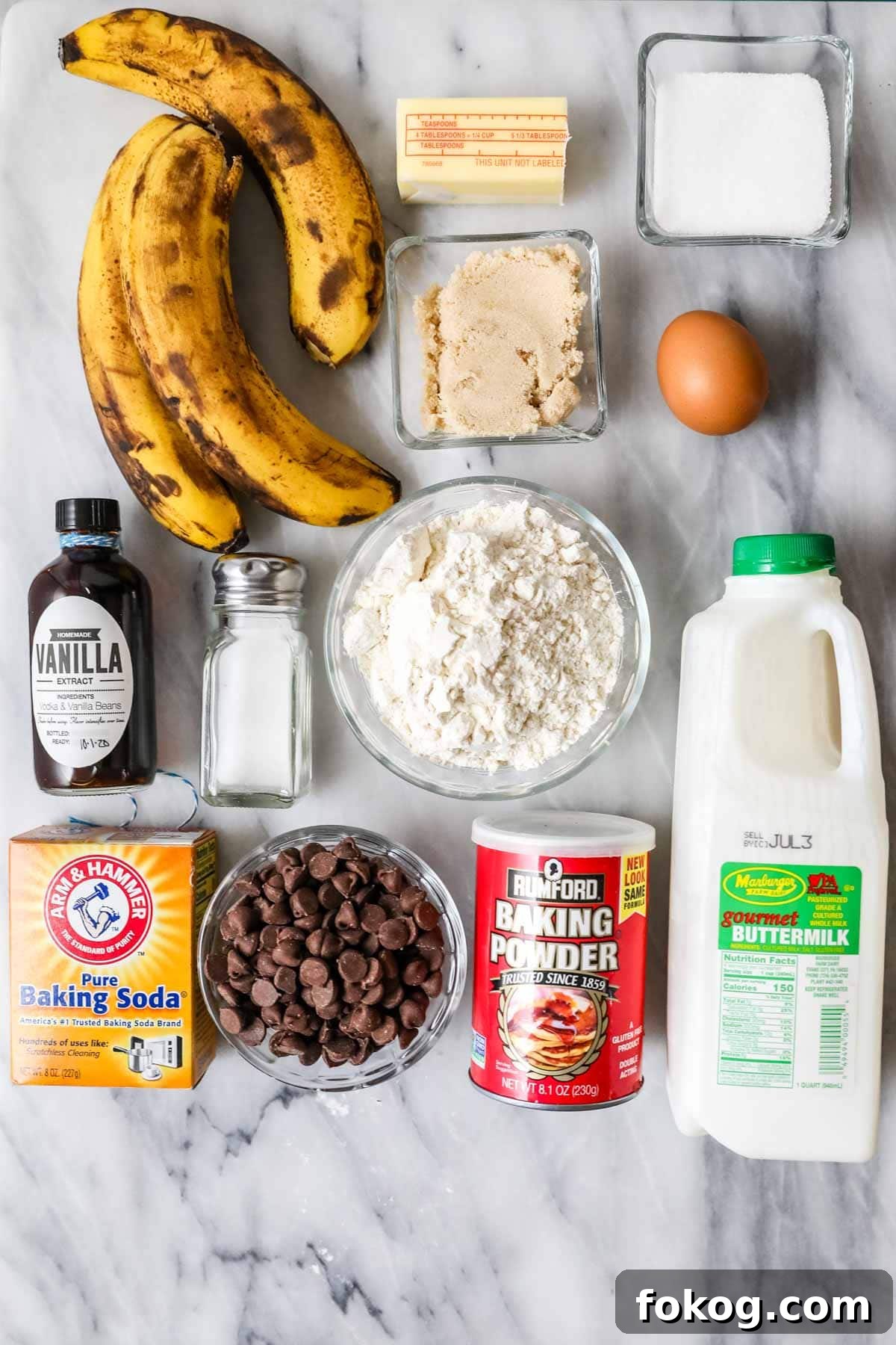 Overhead view of ingredients including bananas, buttermilk, chocolate chips, and more.