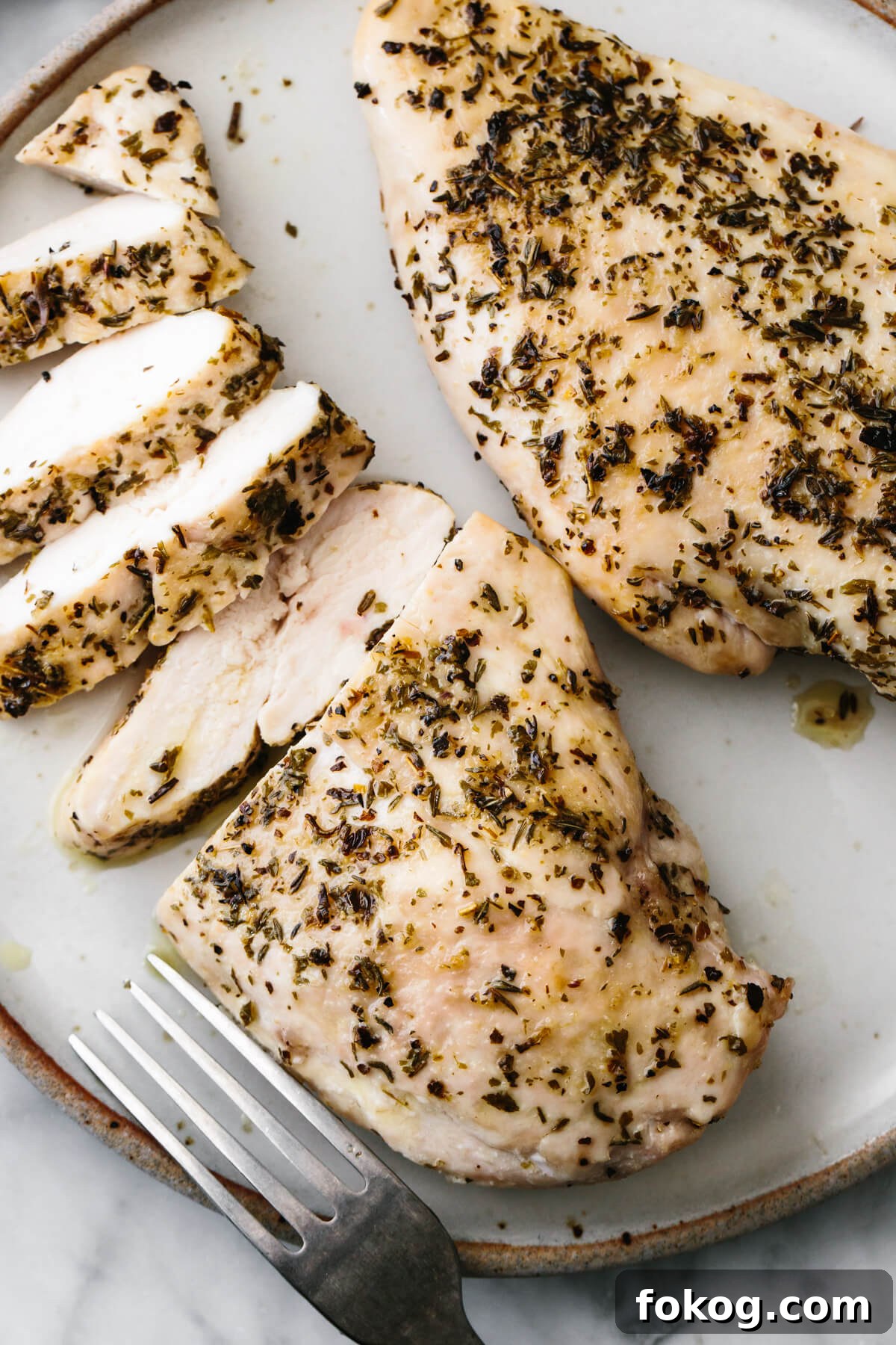 40+ Low-Carb Recipes for Weight Loss and Blood Sugar Control 3 Herb baked chicken breast sliced into pieces on a plate.