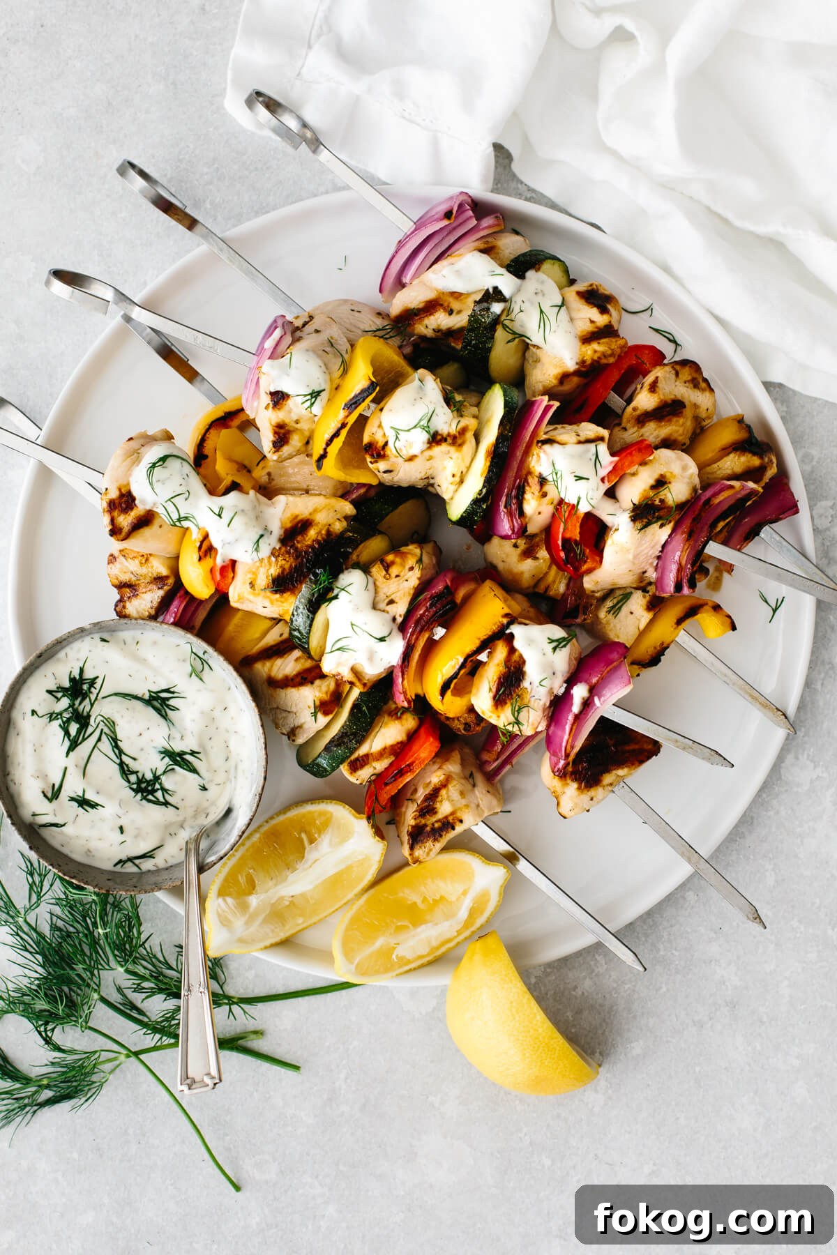 40+ Low-Carb Recipes for Weight Loss and Blood Sugar Control 4 Greek chicken kabobs on a white plate with tzatziki sauce.