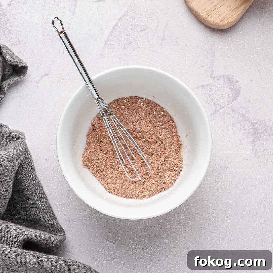A small bowl whisking together the smoky dry rub seasoning.