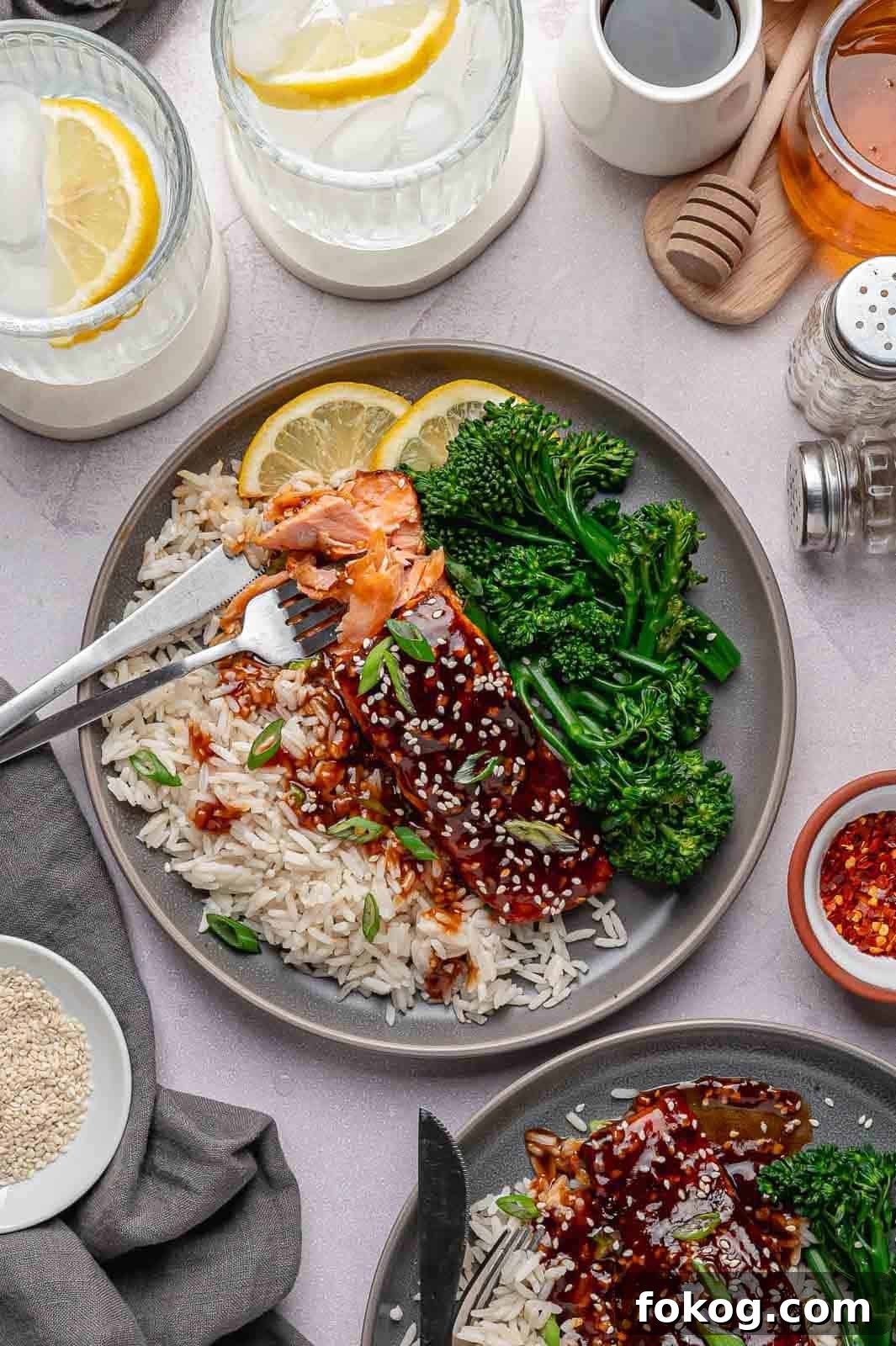 A flaky fillet of Spicy Honey Garlic Salmon served over jasmine rice with roasted broccoli and a caramelized glaze.