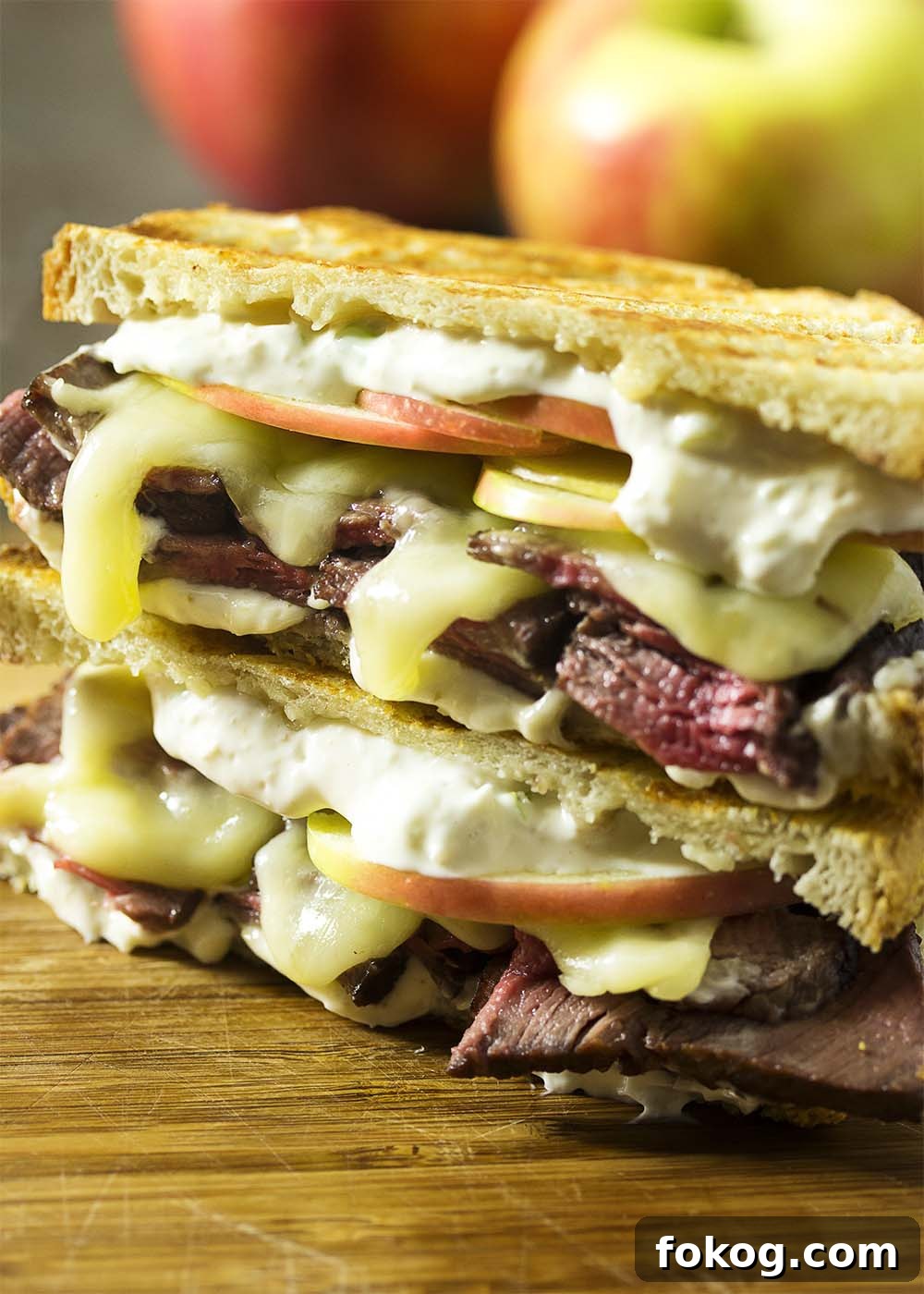 Stacked roast beef paninis on a cutting board