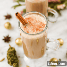 A white countertop with a glass cup filled with cannabis chai latte.