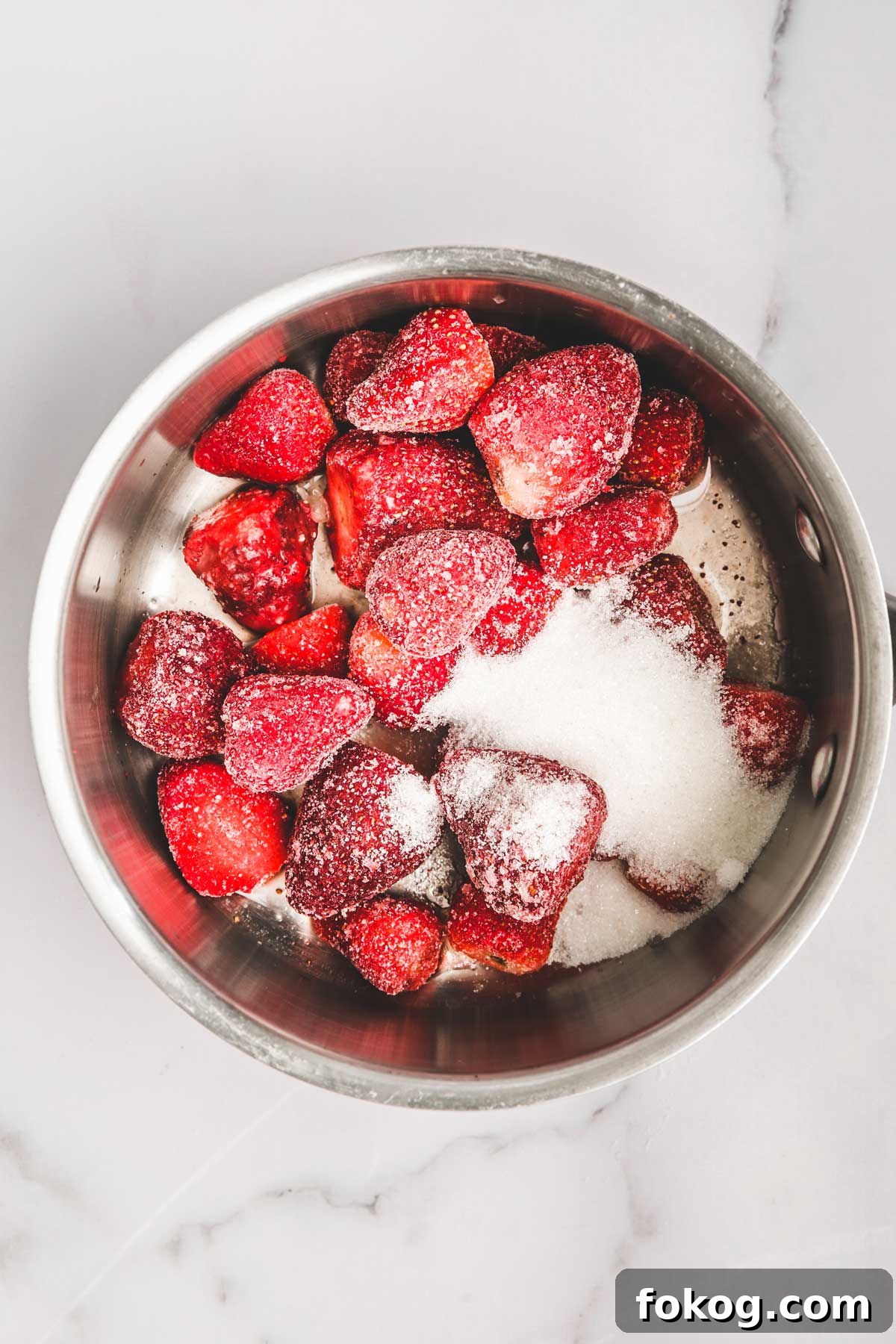 saucepan with strawberries and sugar cooking for strawberry puree