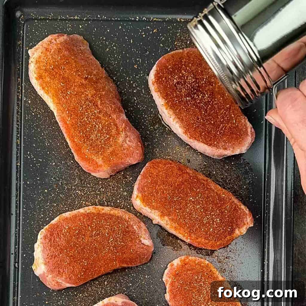 Smoked Thin-Cut Pork Chops on a Traeger Grill 5 The pork chops being seasoned with the homemade pork rub.