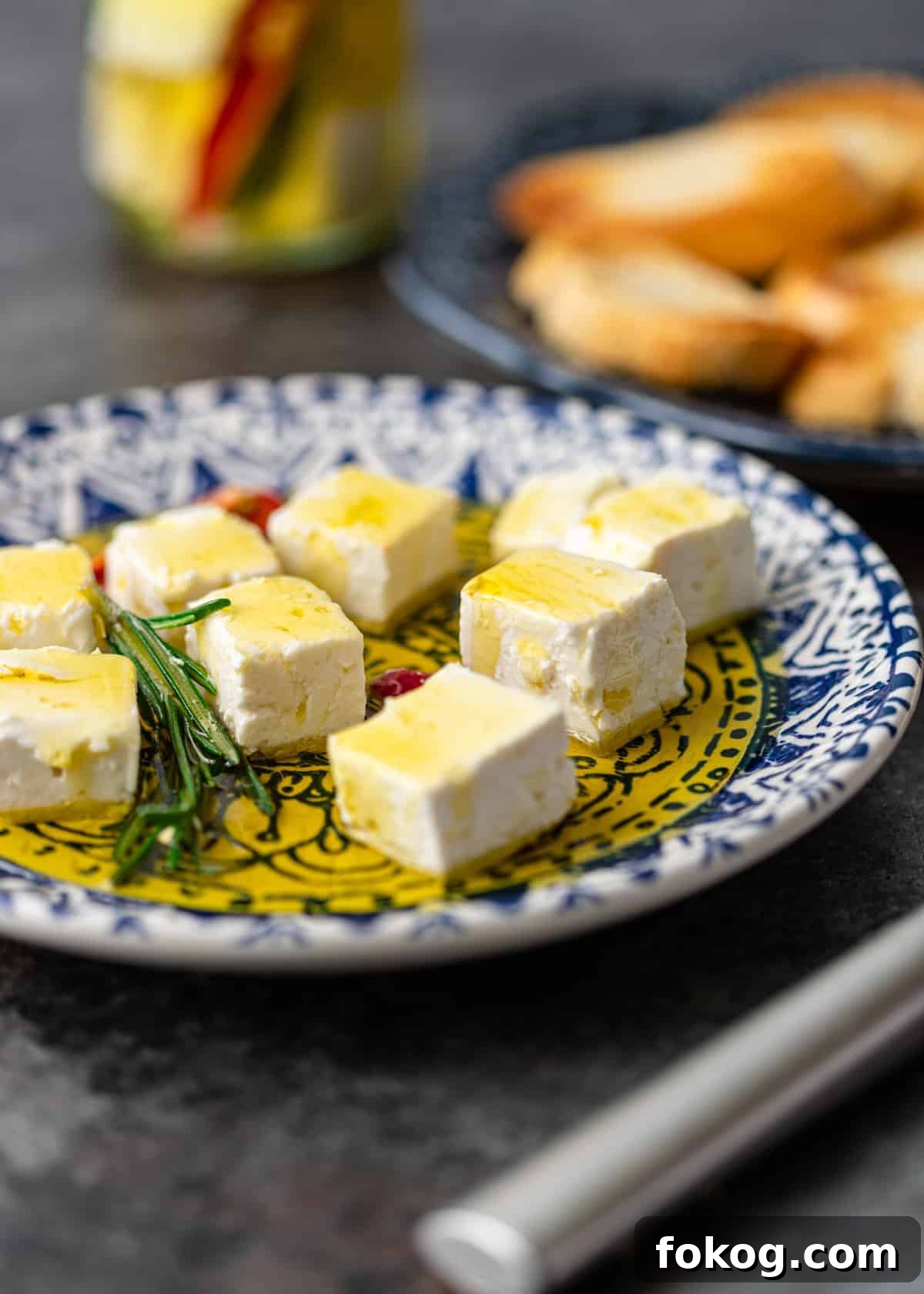 Herbed and Chili-Marinated Feta: Flavorful Appetizer Recipe 3 white marinated cheese cubes on small appetizer plate