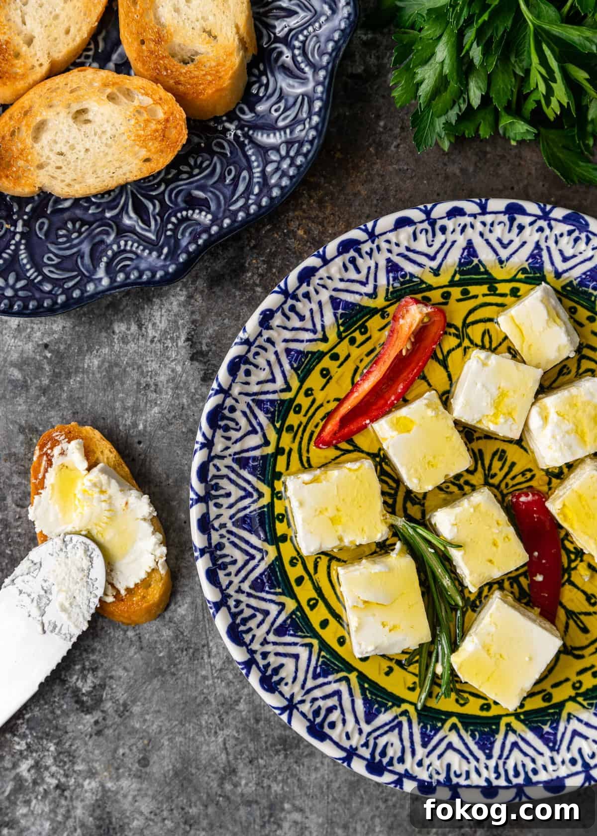 Herbed and Chili-Marinated Feta: Flavorful Appetizer Recipe 6 overhead of a blue plate of marinated feta with herbs and chiles