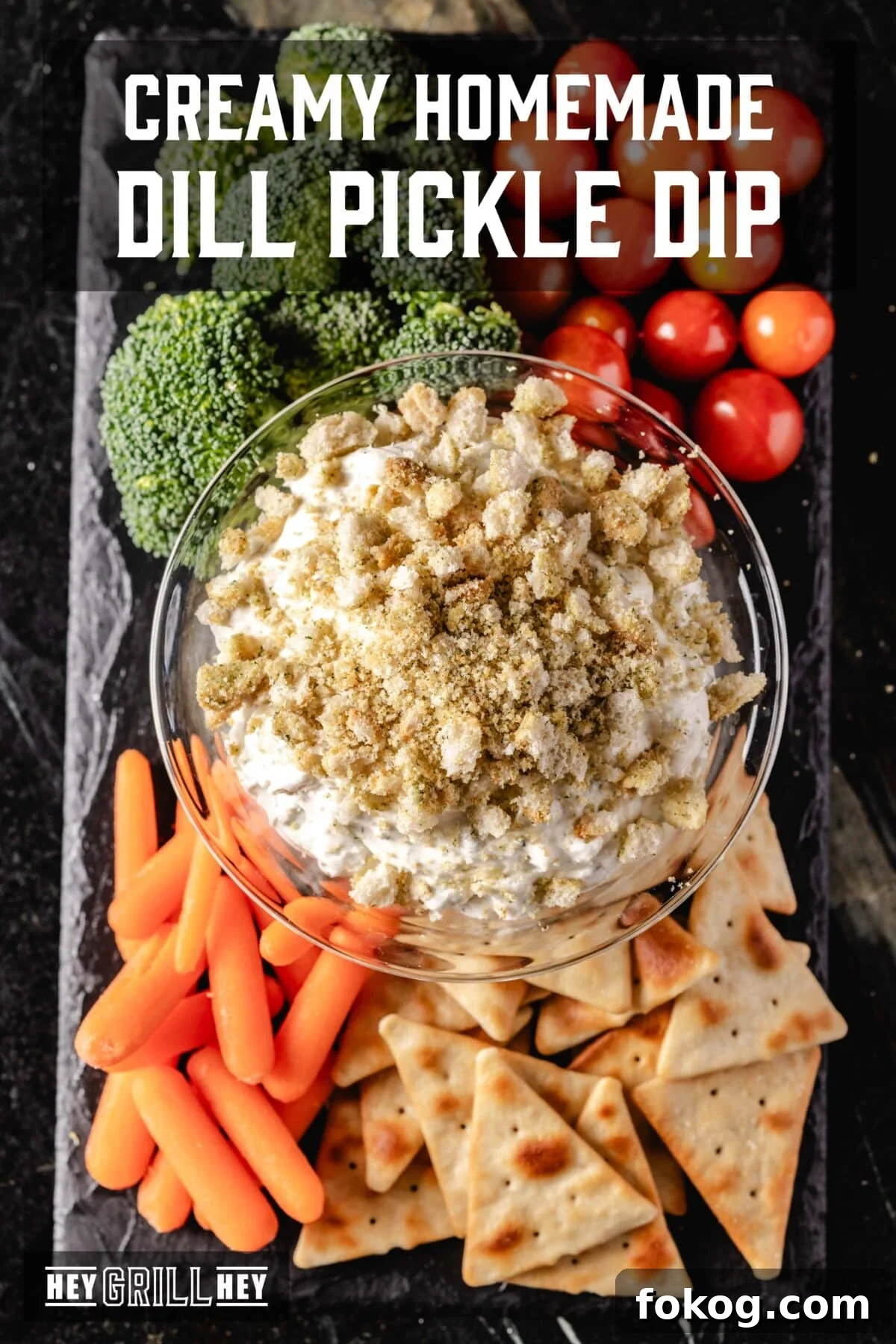 An overhead shot of a dip on a board lined with various veggies.