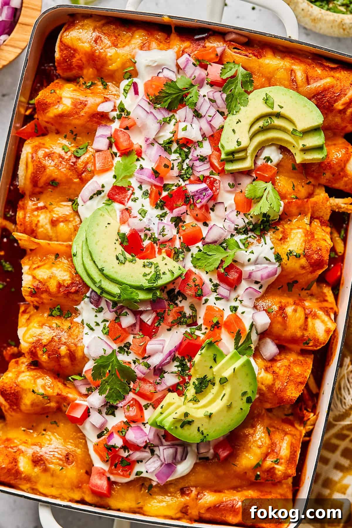 Chicken and Black Bean Enchiladas with Tangy Salsa Verde 2 Chicken and black bean enchiladas with toppings in a casserole dish