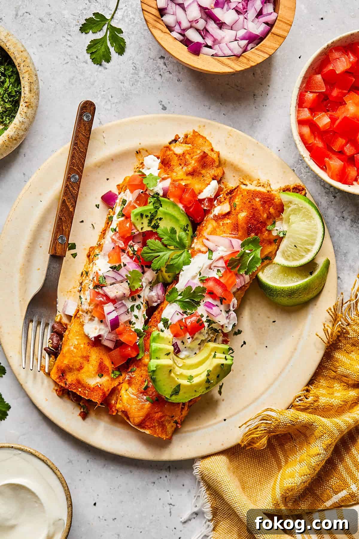 Chicken and Black Bean Enchiladas with Tangy Salsa Verde 9 two enchiladas served on a white plate topped with salsa and avocado