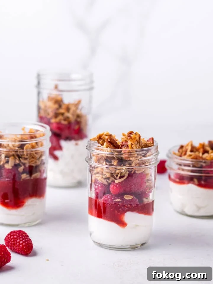 Creamy Raspberry Parfait Recipe with Crunchy Granola 9 rasberry Greek yogurt and granola parfaits in jars
