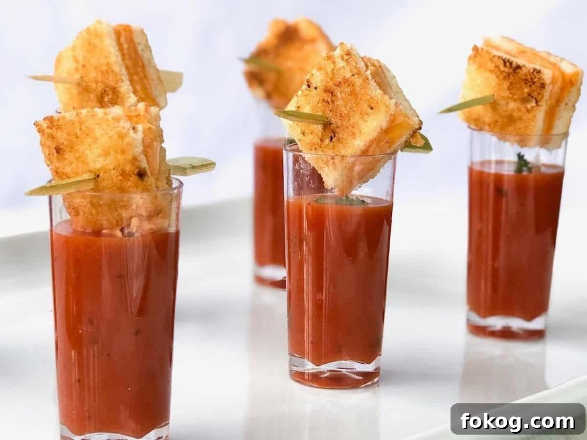 Grilled cheese cubes over top of tomato soup shooters.