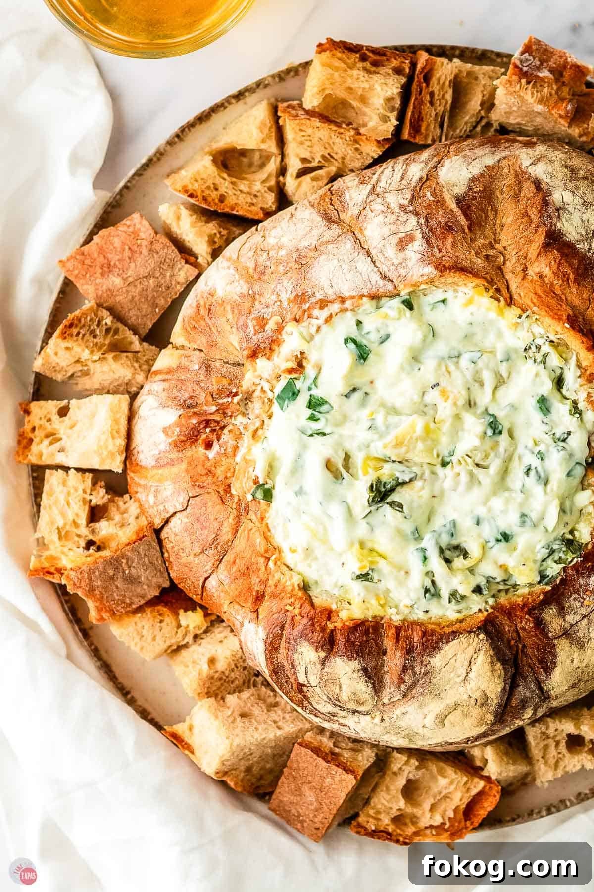spinach dip with artichokes in a bowl made of bread
